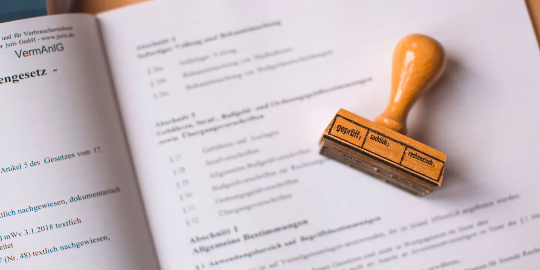 Holzstempel auf einem aufgeschlagenen Buch als Symbol für eine schulische Attestpflicht